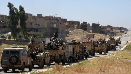 Iraqi government forces drive down a road leading to Tal Afar on June 9, 2017, during ongoing battles to retake the city from Islamic State (IS) group fighters. / AFP PHOTO / MOHAMED EL-SHAHED (Photo credit should read MOHAMED EL-SHAHED/AFP/Getty Images) AFP_PE8R5