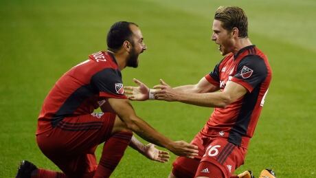 Toronto FC midfielder Nicolas Hasler, right, celebrates his goal against the Philadelphia Union with Victor Vazquez in Wednesday's 3-0 win. toronto fc