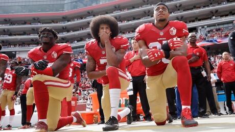 Former San Francisco quarterback Colin Kaepernick, centre, remains a lightning rod for his refusal to stand for the American national anthem. Trumps America Unlikely Alliance Photo Gallery