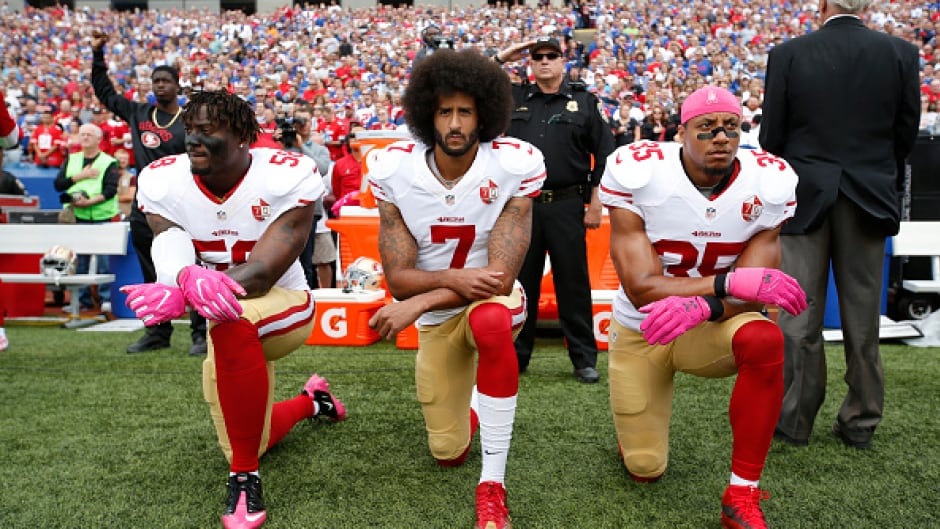 Eli Harold, Colin Kaepernick (centre) and Eric Reid of the San Francisco 49ers kneel in protest on the sideline during the national anthem at New Era Field in New York on October 16, 2016.