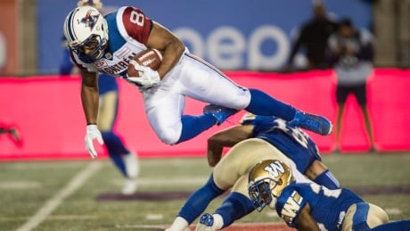 Montreal Alouettes slotback Nik Lewis, left, leaps over Winnipeg Blue Bombers defensive back Taylor Loffler (16) during the first half on Thursday in Montreal. lewis-nik-082417-620