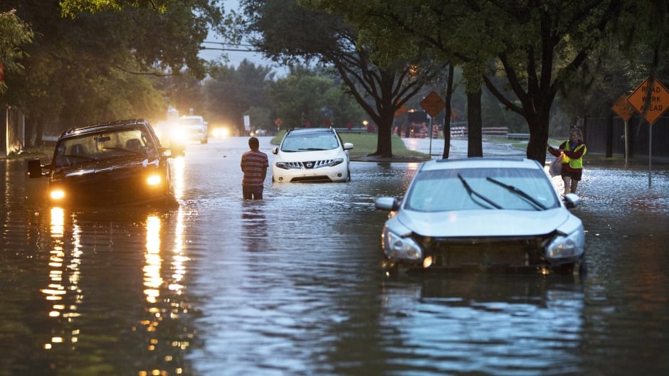 Vehicles are abandoned along flooded Dairy Ashford Drive in Houston, Texas, on Monday.