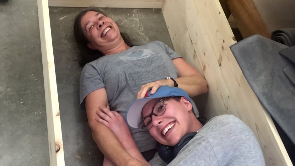 Libby Hoops and her daughter Sarah take a break inside the coffin they built.