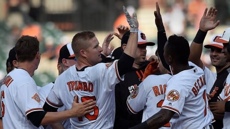 Mark Trumbo, centre, is congratulated after driving in the winning run against the Toronto Blue Jays in the 12th inning of Sunday afternoon's 5-4 victory. Blue Jays Orioles Baseball