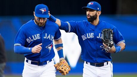 Toronto Blue Jays centre fielder Kevin Pillar, left, is congratulated by teammate Jose Bautista after making an inning-ending catch in the fifth. pillar-kevin