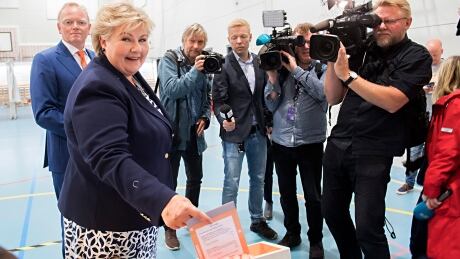 Norway's Prime Minister Erna Solberg casts her ballot at a polling station in Bergen, during the general election on Sept. 11. In the background at left is her husband, Sindre Finnes. As predicted, Norway's national election has shaped up as a tight contest. Norway Election