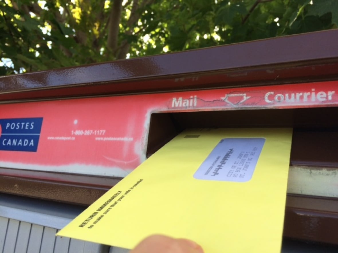 An envelope going into a mailbox. 