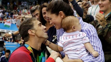Olympic swimming icon Michael Phelps, left, says he's content to be away from the pool and is looking forward to having his second child with wife Nicole. Phelps Interview Swimming