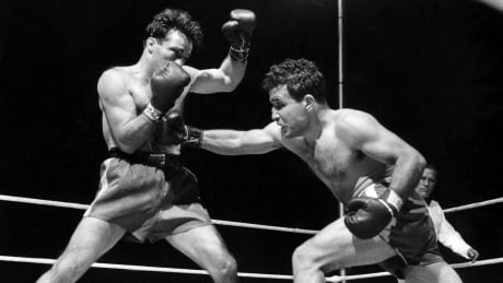 FILE - This June 16, 1949, file photo, shows Jake LaMotta, right, fighting Marcel Cerdan in Briggs Stadium in Detroit, Mich. LaMotta knocked out Cerdan in the tenth round to become the new world middleweight champion. LaMotta, whose life was depicted in the film “Raging Bull,” died Tuesday, Sept. 19, 2017, at a Miami-area hospital from complications of pneumonia. He was 95. (AP Photo/File) Obit Jake LaMotta Boxing