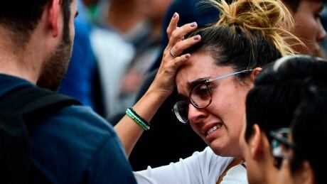 A distressed woman with a relative possibly buried under the rubble of a building knocked down by the powerful 7.1-magnitude quake on the eve, awaits for news from the rescue teams, in Mexico City, on September 20, 2017.
At least 216 people were killed, including 21 children crushed beneath an elementary school that was reduced to rubble. AFP_SM48A