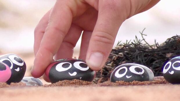 Karen Tuplin placing painted rocks