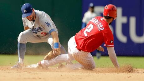 Philadelphia Phillies' J.P. Crawford attempts to slide under the tag of Los Angeles Dodgers shortstop Chris Taylor on Thursday. The Dodgers earned a 5-4 win to clinch at least a tie in the National League West division. Crawford-J.P-09212017