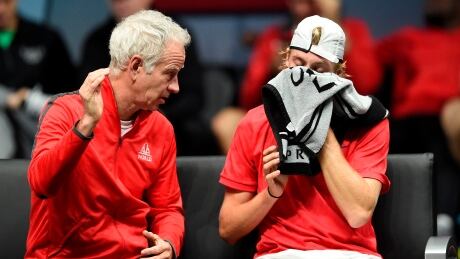 Team World captain John McEnroe talks with Denis Shapovalov during the Canadian's 6-7(3), 6-7(5) loss to Team Europe's Alexander Zverev at the Laver Cup on Friday. AFP_SO5RG