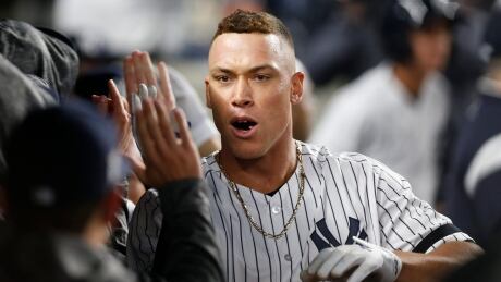 New York Yankees' Aaron Judge celebrates in the dugout with teammates after hitting a two-run home run during the fourth inning. judge-aaron