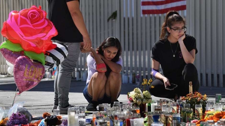 Briana Calderon, centre, and Cinthya Olbera pray at a makeshift memorial on the Las Vegas Strip on Oct. 3, after a gunman killed 59 people and wounded more than 500 others when he opened fire from the Mandalay Hotel on a country music festival.