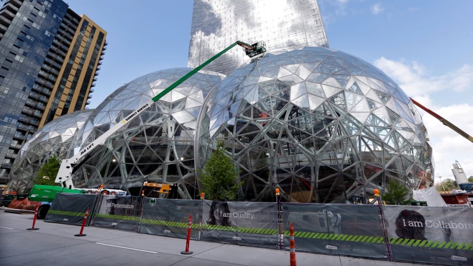 FILE - In this April 27, 2017 file photo, construction continues on three large, glass-covered domes as part of an expansion of the Amazon.com campus in downtown Seattle. Amazon said it will spend more than $5 billion to build another headquarters in North America to house as many as 50,000 employees.
