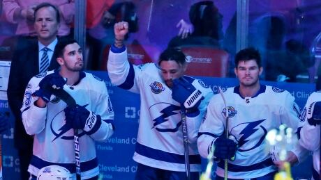 Tampa Bay Lightning right wing J.T. Brown, center, raises his fist in the air during the singing of the national nnthem before Saturday's game against the Florida Panthers. brown-jt-100717