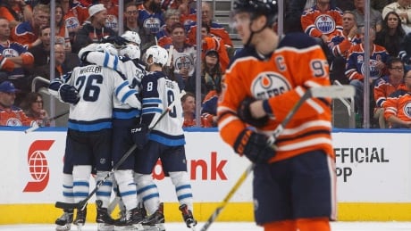 Winnipeg Jets celebrate a goal as Edmonton Oilers' captain Connor McDavid skates past during second-period action at Rogers Place on Monday night. HKN JETS OILERS 20171009