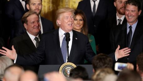 Penguins co owners, Ron Burkle, left, and Mario Lemieux, right, along with first lady Melania Trump crack a smile as U.S. President Donald Trump speaks at Tuesday's event at the White House honouring the two-time defending Stanley Cup champions. trump-donald-171010-1180