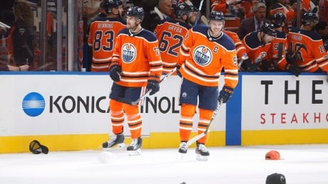 Oscar Klefbom and Connor McDavid wait for hats to be picked up off the ice after the Edmonton Oilers' captain scored a hat trick against the Calgary Flames during the season opener a week ago. FLAMES OILERS 20171004