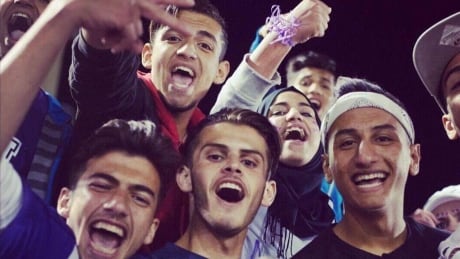 Moiad "Mo" Alhamoud, seen here in the white headband, was excited to go to the Moncton High football game to cheer for the team along with his brother and friends. Mo at football game