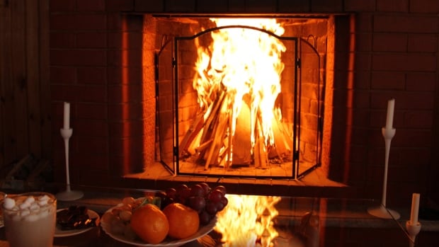 In some ancient traditions, it was believed negative spirits sought refuge within the warmth of human homes during the longest night of the year. Lighting a fire or candles was thought to keep them at bay. A burning fireplace near a fruit plate and a hot chocolate.