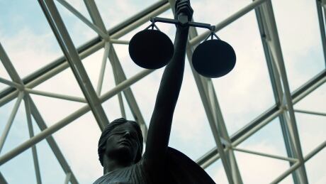 A statue of Lady Justice, blindfolded and holding balanced scales, resides at Vancouver's Supreme Court building. Lady Justice statue at Supreme Court courthouse in Vancouver