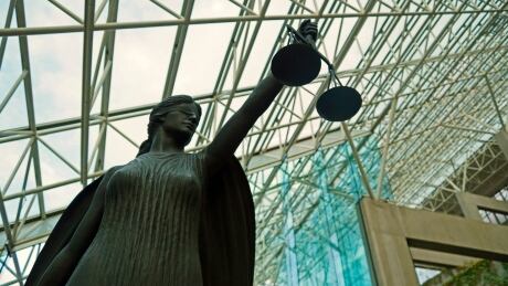 A statue of Lady Justice, blindfolded and holding balanced scales, resides at Vancouver's Supreme Court building. Lady Justice statue at Supreme Court courthouse in Vancouver