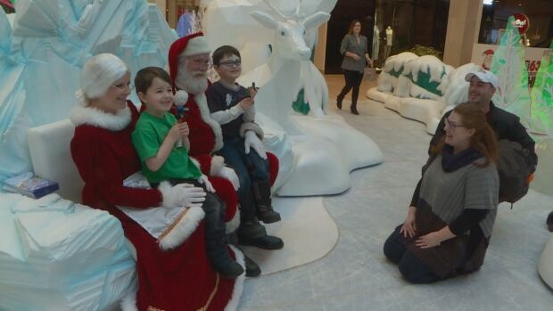 Zach Belisle and his brother Luke visit with Santa and Mrs. Claus