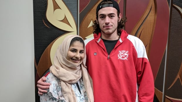 Noor Fadel standing with Jake Taylor, the only passenger to intervene and help her.