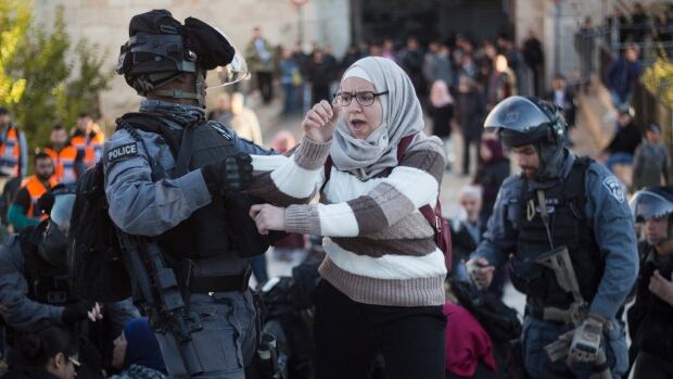 Israeli police officers push away a Palestinian woman during a protest against U.S. President Donald Trump's decision to recognize Jerusalem as the capital of Israel outside Damascus Gate in Jerusalem's Old City on Dec. 8, 2017. 