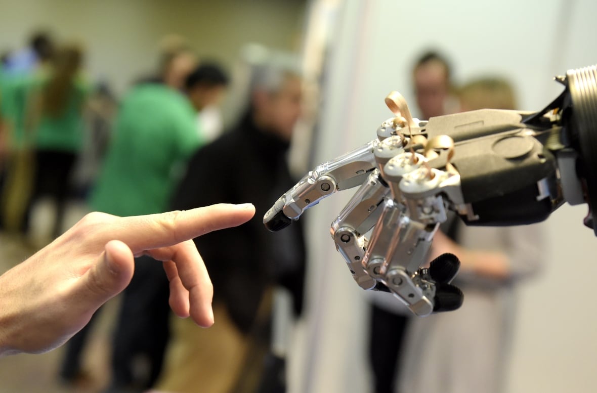 A human hand touches a robotic hand