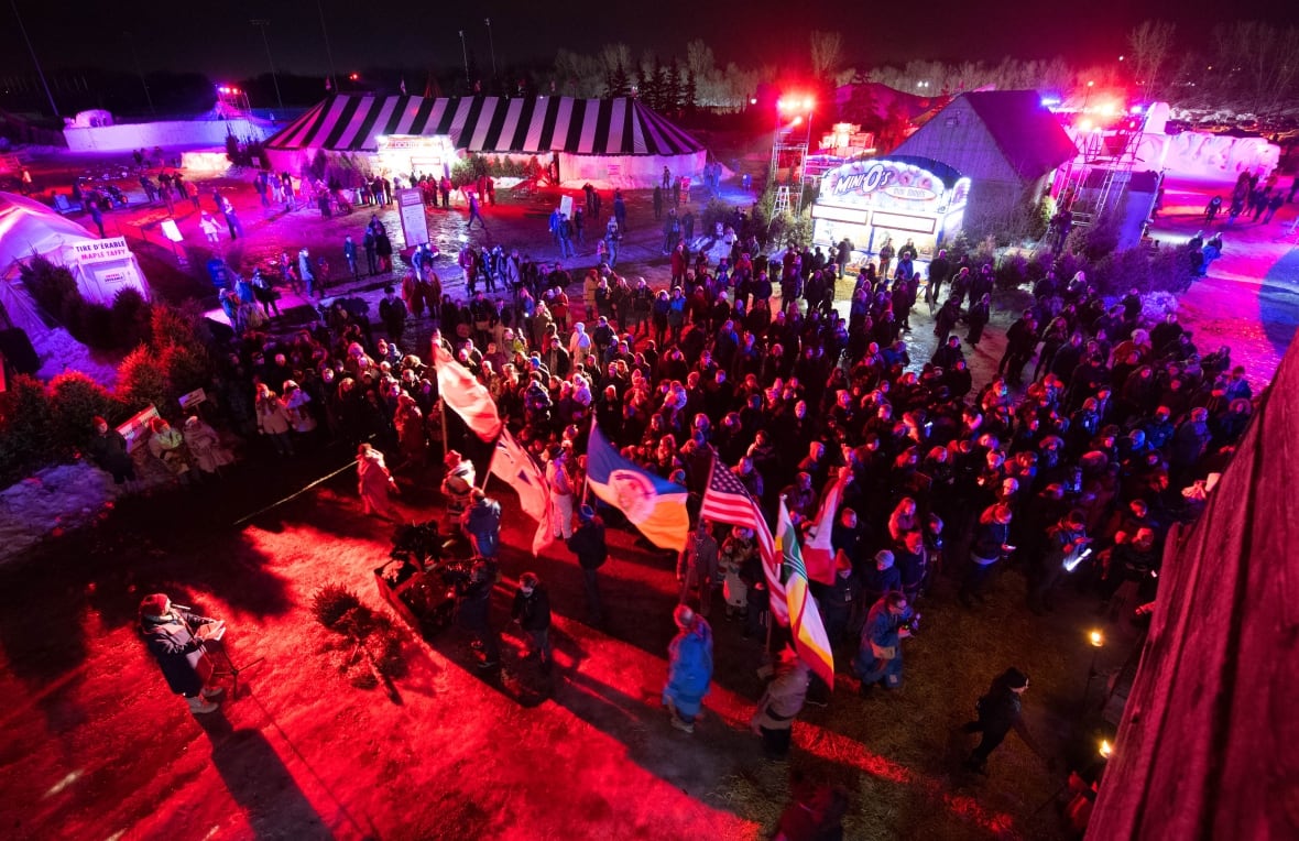 A large crowd gathers at night during a winter festival.