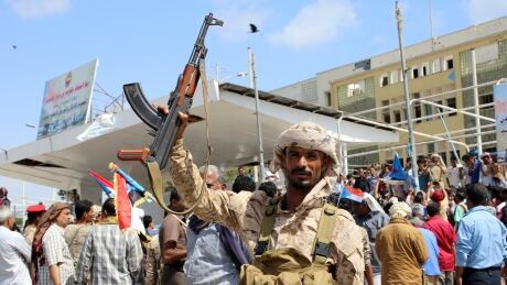A southern Yemeni separatist fighter waves his rifle at the site of an anti-government protest in the port city of Aden on Tuesday. The separatists issued a deadline, now passed, for the government to tender its resignation. YEMEN-SECURITY/CLASHES