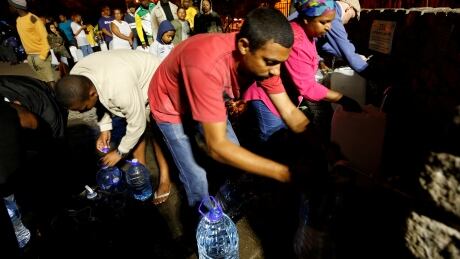 People queue to collect water from a spring in the Newlands suburb as fears over the city's water crisis grow in Cape Town, South Africa, January 25, 2018. Picture taken January 25, 2018. REUTERS/Mike Hutchings - RC1EB37D25C0 SAFRICA-DROUGHT/TOURISM
