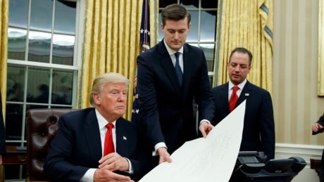 In this Jan. 20, 2017 file photo, Rob Porter hands President Donald Trump a confirmation order to sign. Porter stepped down from his post on Wednesday, following allegations of domestic abuse by his two ex-wives. Trump Aide Resigns
