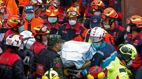 Rescuers on Thursday carry the body of a victim recovered from a collapsed building collapsed after a strong earthquake in Hualien County, eastern Taiwan. Taiwan Earthquake