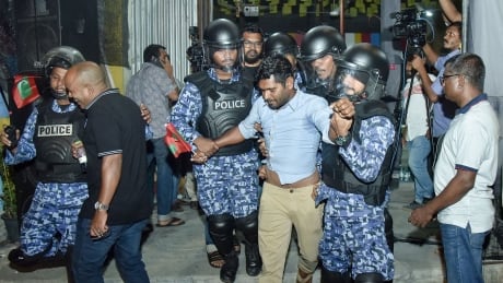This picture taken on February 21, 2018 shows Maldivian police officers detaining an opposition protestor (C) demanding the release of political prisoners during a protest in Male.<br />
Maldives President Abdulla Yameen extended a draconian state of emergency by another month on February 20, ignoring a growing chorus of international concern and calls for democracy to be restored in the honeymoon islands. / AFP PHOTO / Ahmed Shurau (Photo credit should read AHMED SHURAU/AFP/Getty Images) AFP_10V0CF
