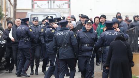 Police officers gather near a drug abuse treatment centre that caught fire in Baku, Azerbaijan on Friday.<br />
<br />
<br />
<br />
AZERBAIJAN-FIRE/