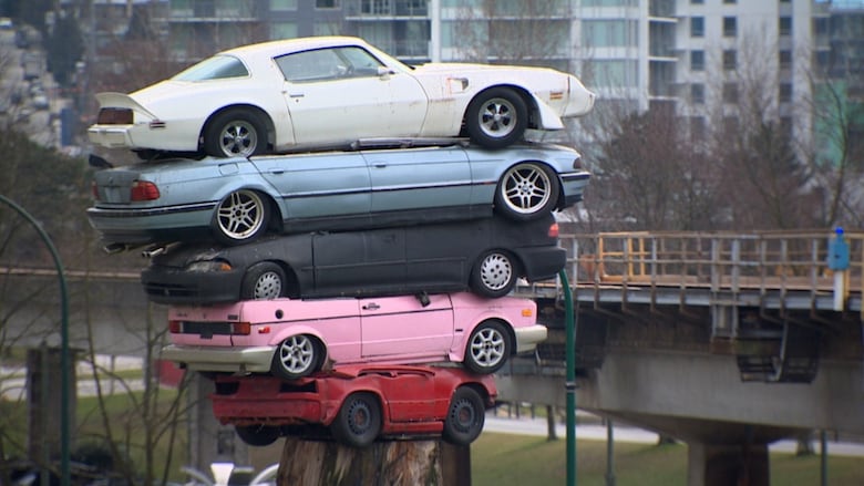 The Trans Am Rapture public art installation with stacked cars on a tree stump