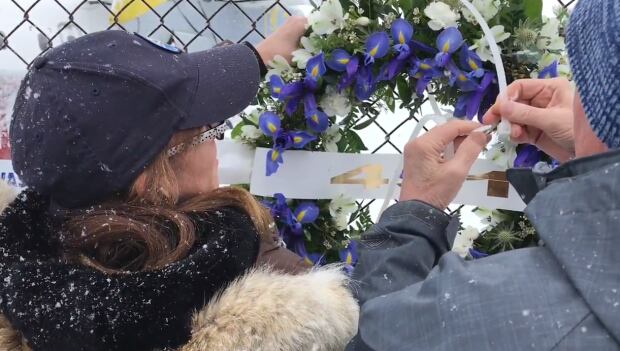 Lori Chynn hangs a memorial wreath