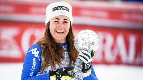 Sofia Goggia of Italy celebrates with the Crystal Globe after taking the overall World Cup downhill title in Are, Sweden on Wednesday. goggia-sofia-031418-620