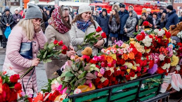 People lay flowers for the victims of a fire in a multi-storey shopping centre in the Siberian city of Kemerovo, about 3,000 kilometres east of Moscow, Russia, on Monday.  The mall was packed with children and their families. 