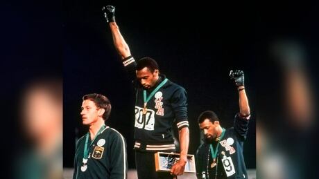 Americans Tommie Smith, centre, and John Carlos raise their gloved fists in a human rights protest at the 1968 Olympics. norman-peter