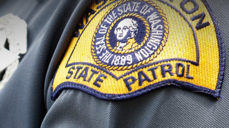 A shoulder patch on a police officer reads 'Washington State Patrol' with a symbol of George Washington.
