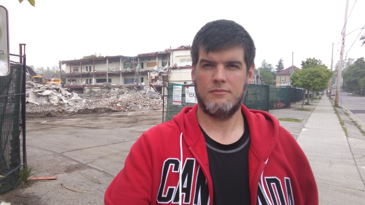 A man in front of a torn up lot