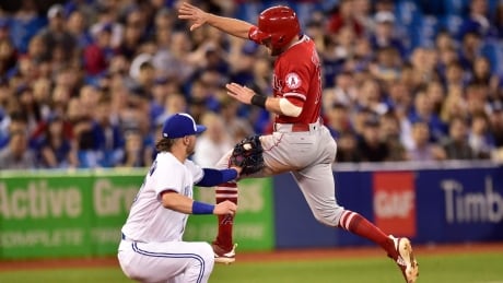 Toronto's Josh Donaldson tags out a leaping Zack Cozart in the sixth inning of the Angels' 5-4 win over the Jays on Wednesday. BBA Angels Blue Jays 20180523