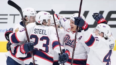 Host Regina Pats forward Nick Henry (21) celebrates his goal over the Swift Current Broncos with his teammates during the first period of a Memorial Cup game. pats-current
