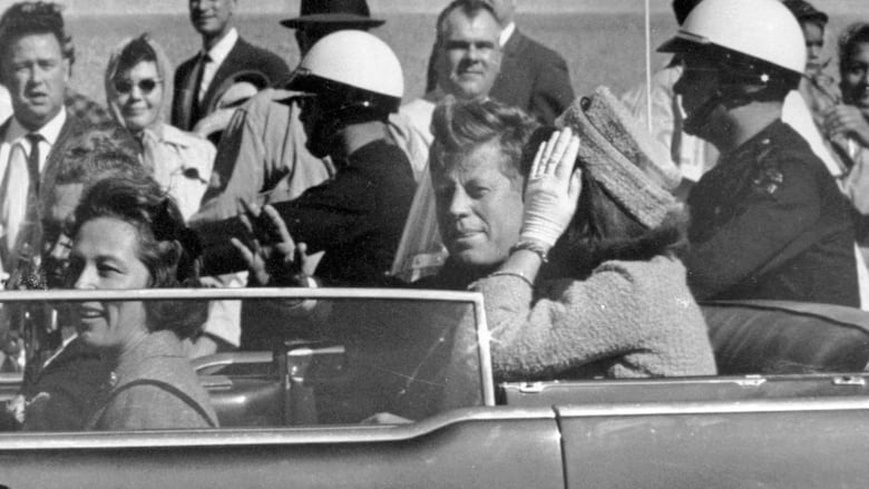 A white and black picture of a man and a woman sit on a car.