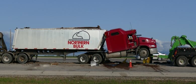 The semi was hoisted onto a tow truck as crews cleaned up 